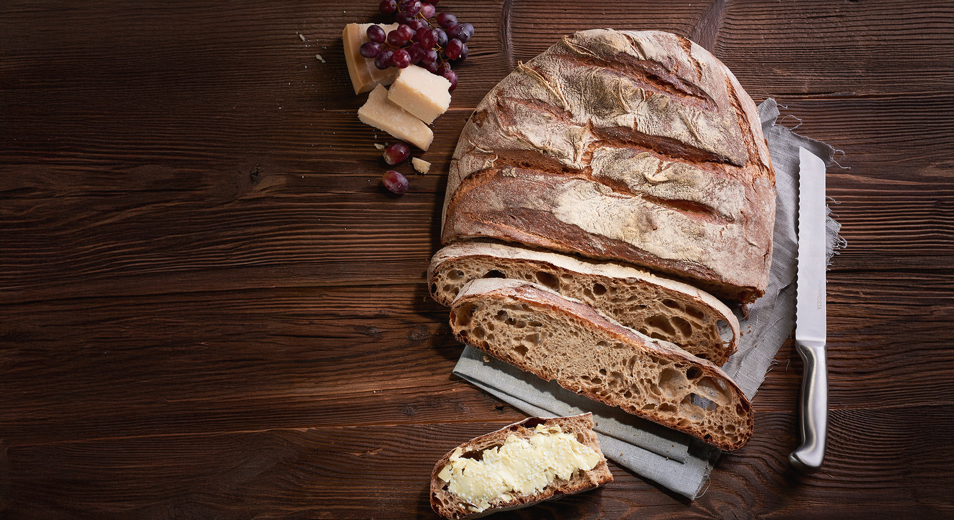 Ein aufgeschnittenes Tessino mit Käse, Wein und Weintrauben
